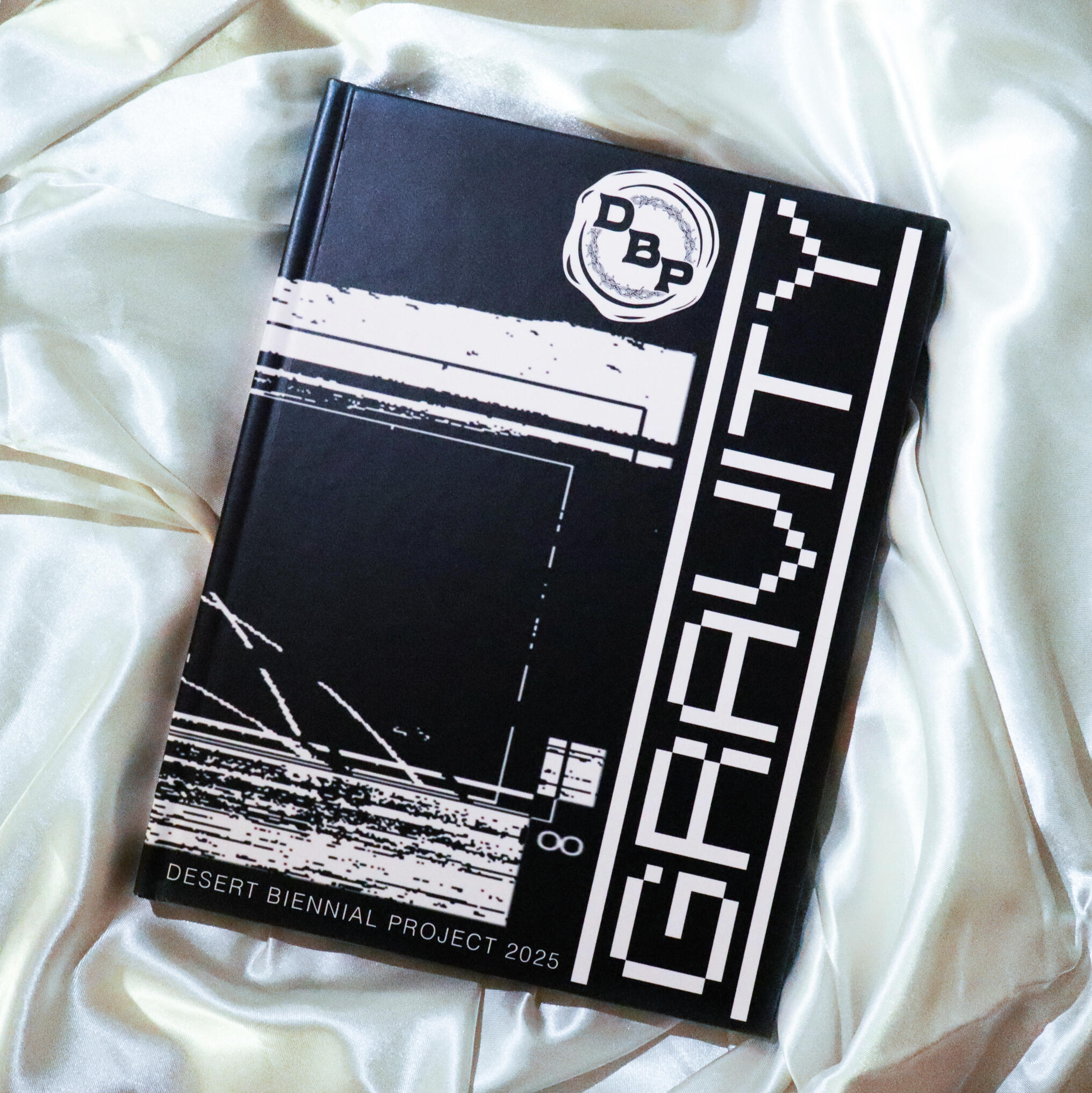 Image from Stone Soup event from 2023 Desert Biennial Project. Features bright orange diamond sign with black lettering spelling out Desert Biennial Project behind a sign made from dimensional lumber with Stone Soup painted in red on front of sign.