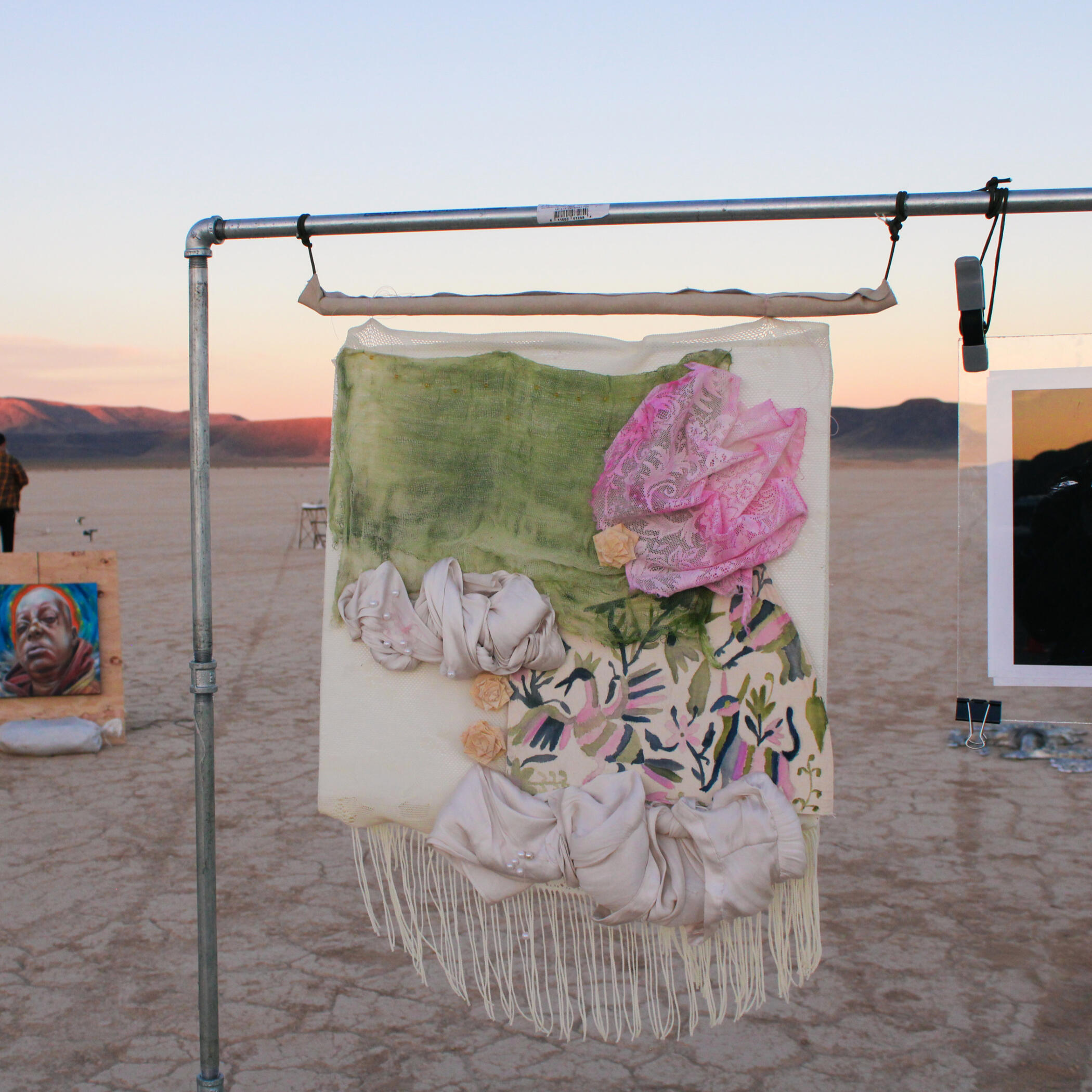 Image of a sunny, bright day in the desert of Nevada. There is a mountain in the horizon line and beneath it is a large desert landscape full of shrubs and yellow grass.