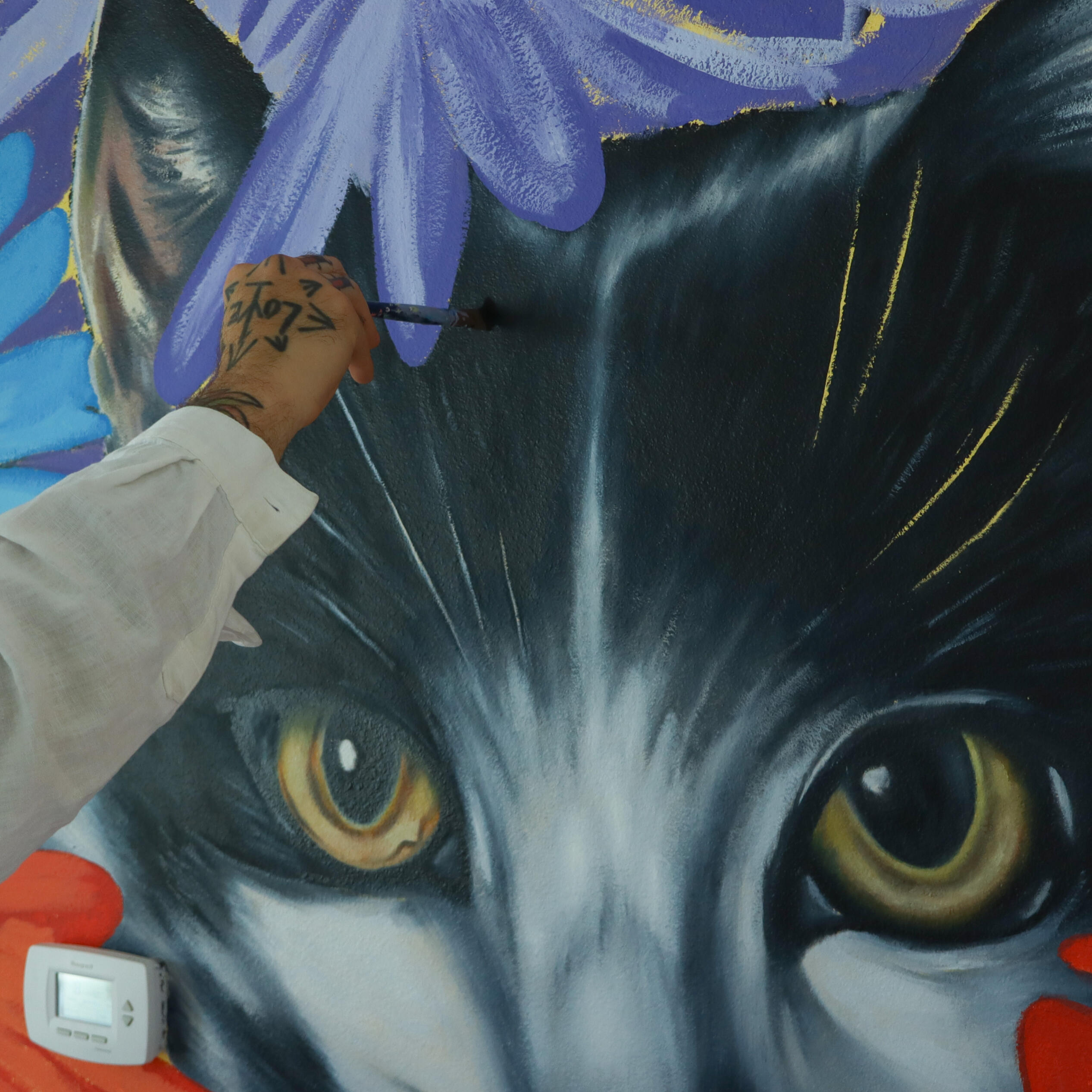 Image from Stone Soup event from 2023 Desert Biennial Project. Features bright orange diamond sign with black lettering spelling out Desert Biennial Project behind a sign made from dimensional lumber with Stone Soup painted in red on front of sign.