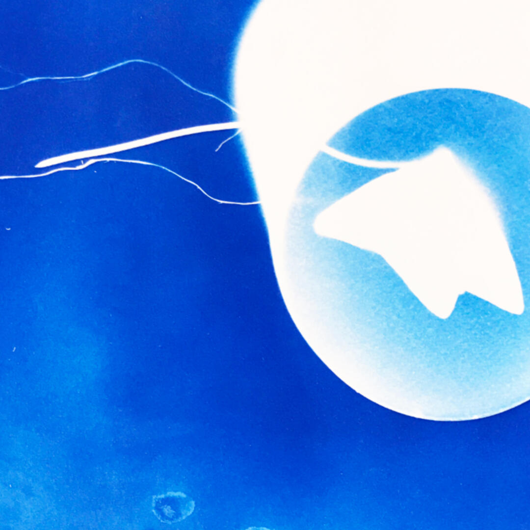 Image from Stone Soup event from 2023 Desert Biennial Project. Features bright orange diamond sign with black lettering spelling out Desert Biennial Project behind a sign made from dimensional lumber with Stone Soup painted in red on front of sign.